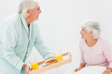 Husband bringing wife breakfast in bed