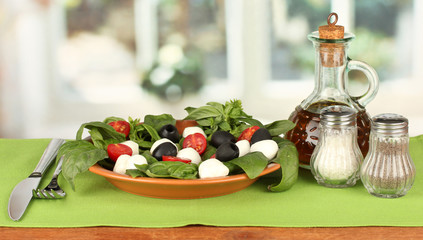 cheese mozzarella with vegetables in the plate with fork and