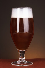 Glass of beer on brown background