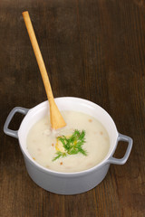 Mashed potatoes in saucepan on wooden table