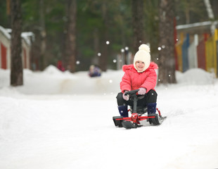 Fototapeta na wymiar Mały Chłopiec i dziewczynka ześlizguje się ze wzgórza śnieg na sankach