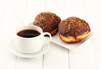 Tasty donuts on color plate on light wooden background