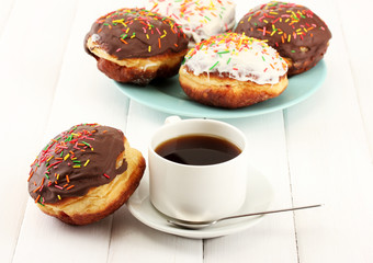 Tasty donuts on color plate on light wooden background