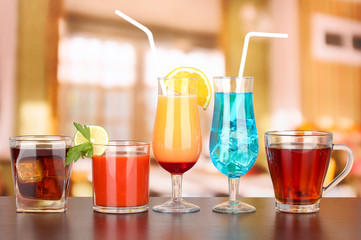 Several glasses of different drinks on bright background