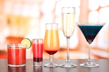 Several glasses of different drinks on bright background