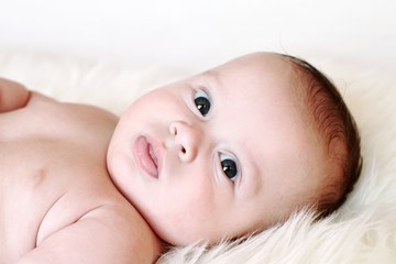 The serious baby lies on a fur plaid (3,5 months)