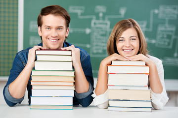schüler stützen sich auf bücherstapel