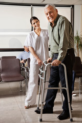 Female Nurse Helping Senior Patient With Walker