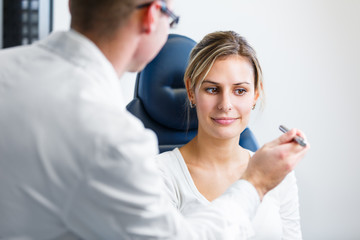 Optometry concept - pretty young woman having her eyes examined