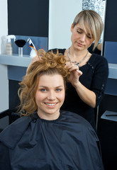 Fototapeta premium hair stylist curling woman hair