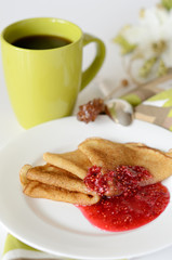 Pancakes with jam and a cup of coffee for breakfast