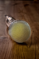Microphone on wooden background