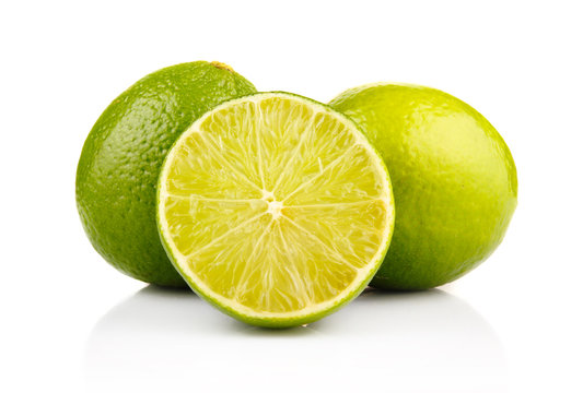 Ripe lime fruits with slices isolated on white