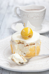Sweet cake with cup of tea on white wooden table