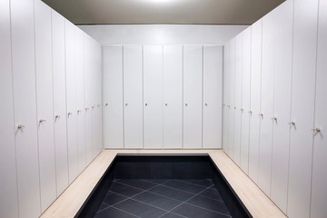 Gym dressing room with lots of white lockers