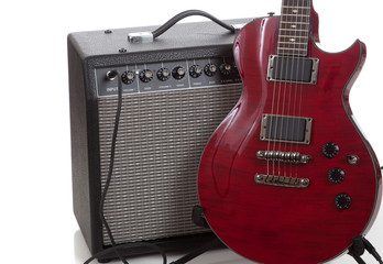 An electric guitar with a black amp on  a white background
