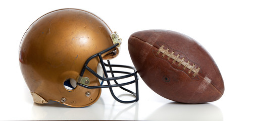 A retro gold football helmet and football on a white background