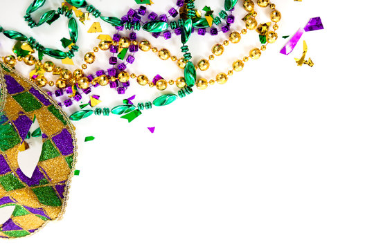 A Mardi gras mask and beads on a white background with copy spac