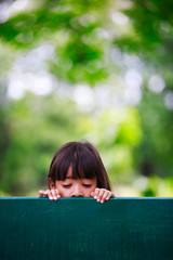 Sad little girl sits on bench