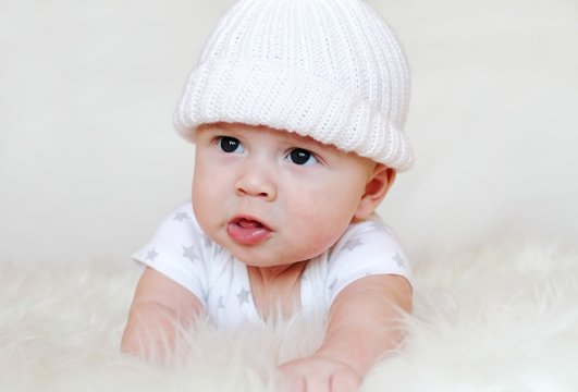 The angry baby in a white knitted cap (3,5 months)