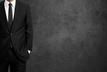 man in suit on a concrete wall background
