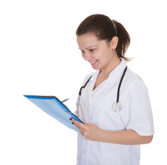 Cheerful young nurse writing a report