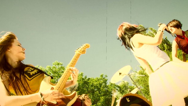Girls band performing outdoors. Old movie.