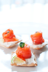 Canapes with smoked salmon and cream cheese on white plate
