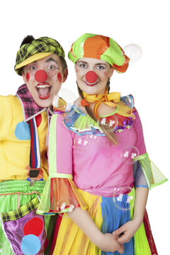 Two cheerful clowns in the soap bubbles