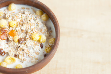 bowl of oat cereal with milk on a wooden surface