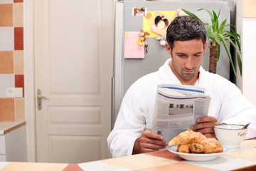 Man reading his newspaper over breakfast