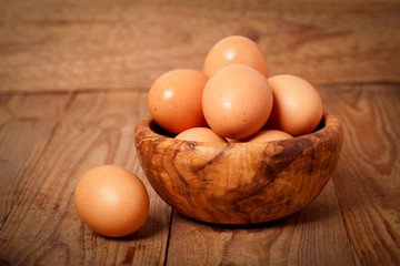 fresh brown eggs on wooden background