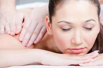 Obraz na płótnie Canvas Woman receives massage treatment at beauty salon