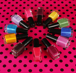 bright nail polishes on table on black background