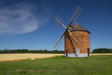 Fototapeta na wymiar Landscape with a brick windmill