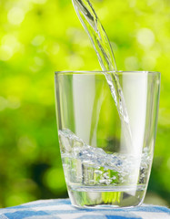 Glass of water on nature background