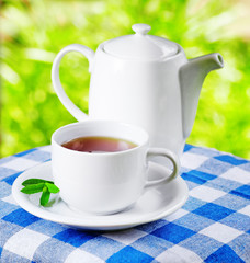 Cup of tea on nature background