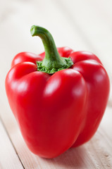 Close-up of a red bell pepper on wooden boards, studio shot
