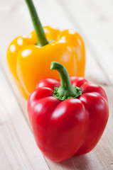 Red and yellow bell peppers on wooden boards, vertical shot