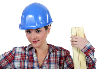 Tradeswoman holding a plank of wood