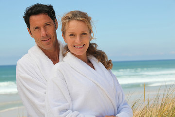 couple in robes on the beach