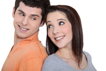Young couple standing back to back