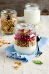 Yoghurt in a glass jar with muesli and currant