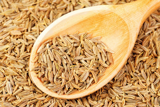 cumin seeds macro and  wooden spoon as background