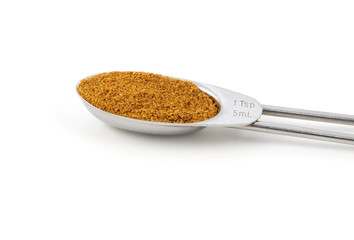 Curry powder measured in a metal teaspoon