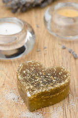 bath soap with lavender in a heart and candles on wooden table