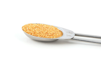Garlic granules measured in a metal teaspoon