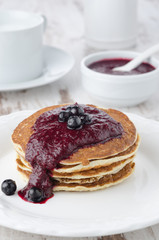 stack of pancakes with black currant jam on a plate,