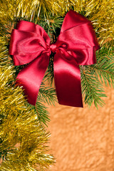 fir branches with red bow on golden background