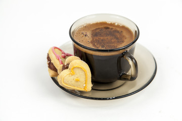 Cup of coffee with heart cookies on white background